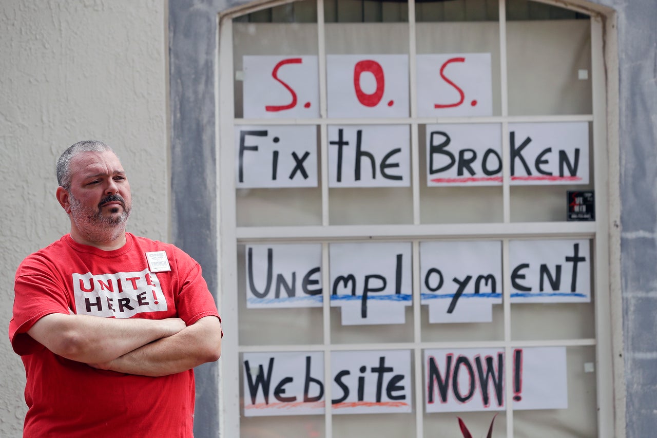 Hew Kowalewski, a furloughed employee of Disney World, stands next to window of his home April 13, in Kissimmee, Florida. Many of Florida's jobless have reported problems filing applications for unemployment benefits.