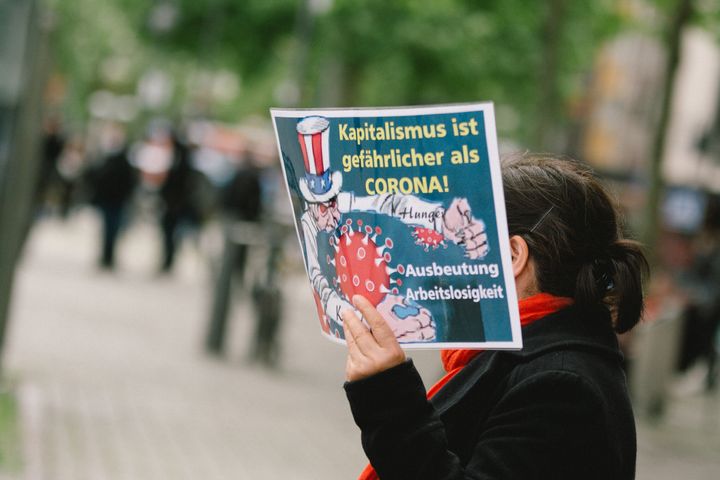 «Ο καπιταλισμός είναι πιο επικίνδυνος από τον κορονοϊό» σύνθημα σε διαδήλωση στην Κολονία 1η Μαΐου on May 2020. (Photo by Ying Tang/NurPhoto via Getty Images)