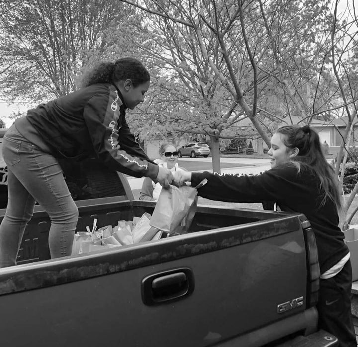 Antone's eldest daughters Hope and Shoshannah help their dad load supplies in his pickup truck.