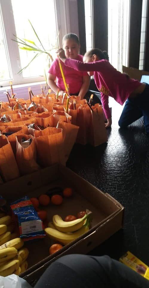 Antone's kids pack cured meat, bananas, oranges and bags of chips into paper bags for Windsor locals.