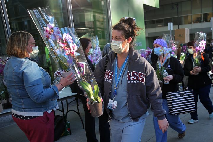 BOSTON, MA - MAY 9: As a small gesture of gratitude during National Nurses Week, and in recognition of their tremendous contributions during the COVID-19 pandemic, Brigham and Womens nurses received orchids outside of the hospital in Boston as they exited on May 8, 2020 after working overnight. Hospital leadership distributed the 390 orchids and gave nurses a well-deserved round of applause for the dedication and courage they exhibit every day and especially during these trying times. This gift was made possible thanks to Home Depot and ICS Plant Specialists. (Photo by David L. Ryan/The Boston Globe via Getty Images)