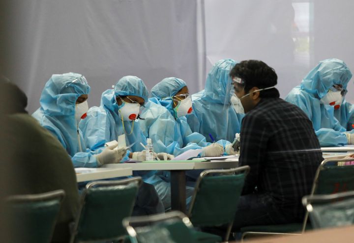 Indian nationals, who were stranded in Singapore due to the coronavirus disease (COVID-19) outbreak, are screened by medics wearing personal protective equipment (PPE) at the airport upon their arrival in New Delhi, India, May 8, 2020. REUTERS/Anushree Fadnavis
