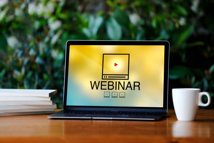 Laptop with webinar screen on wooden desk