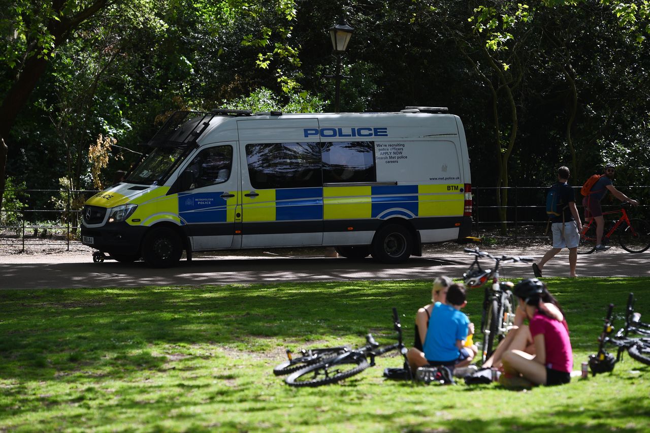 Police drive through Battersea Park on Saturday. 
