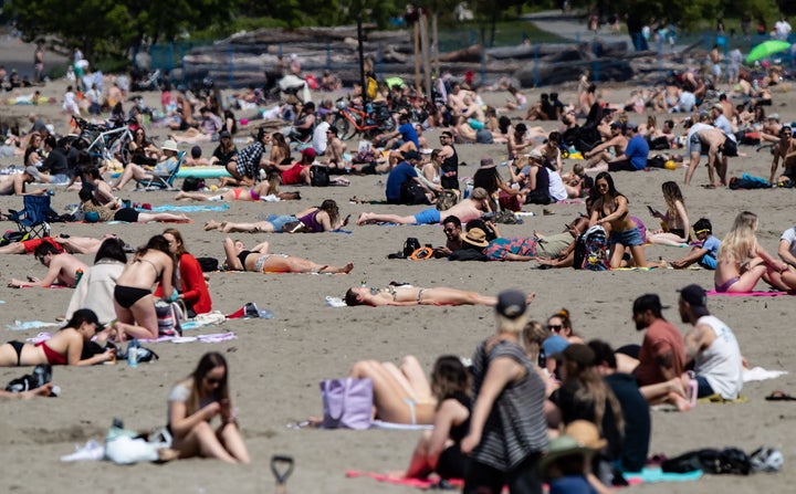 People sun themselves at Vancouver's Kitsilano Beach as temperatures reached into the range of 20 C, according to Environment Canada on May 10, 2020.