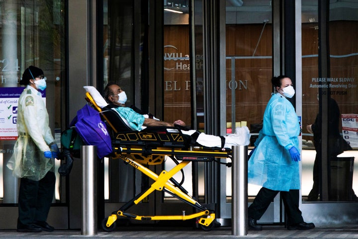 Health workers move a patient wearing a face mask at the at NYU Langone Hospital, during the outbreak of the coronavirus disease (COVID-19) in the Manhattan borough of New York City, New York, U.S., May 3, 2020.