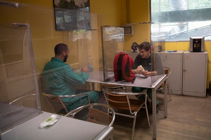 Διάλειμμα εργαζομένων σε εταιρεία στην Ιταλία σε ειδικά διαμορφωμένο χώρο με διαχωρίσματα από πλεξιγκλάς. 
