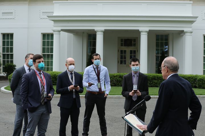 White House Economic Council Director Larry Kudlow, who was not wearing a mask, briefs masked reporters outside the White House on May 8, 2020. 