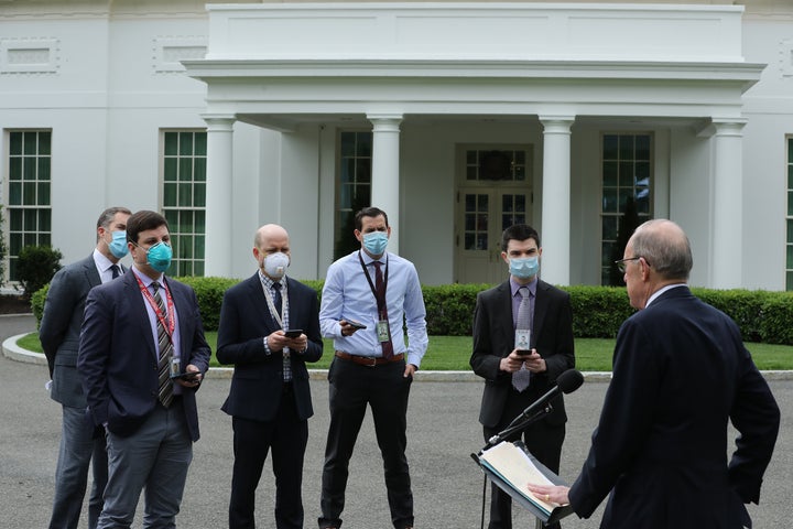 White House Economic Council Director Larry Kudlow, who was not wearing a mask, briefs masked reporters outside the White Hou