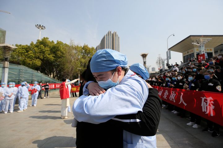 A local medical worker embraces and bids farewell to a medical worker from Jiangsu at the Wuhan Railway Station as the medical team from Jiangsu leaves Wuhan, March 19, 2020. 