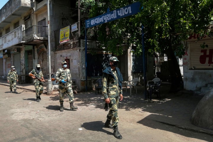 Border Security Force (BSF) soldiers patrol along a street during a government-imposed lockdown in Ahmedabad on May 8, 2020.