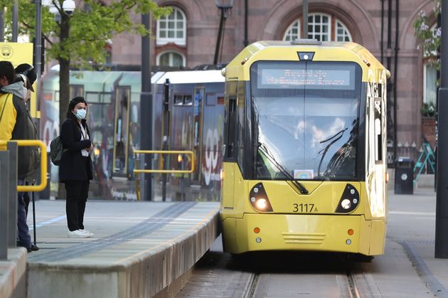 Commuters wait to board a tram in Manchester, after prime minister Boris Johnson said people who cannot work from home should be 'actively encouraged' to return to their jobs