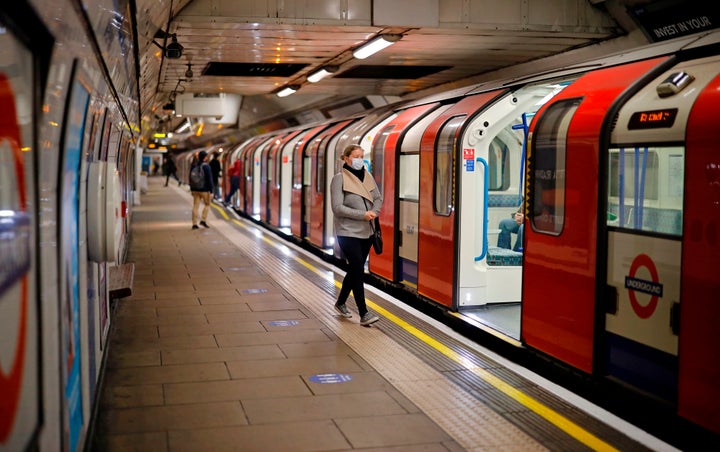 A woman wearing a face mask on a London Underground platform during rush hour, May 11, 2020