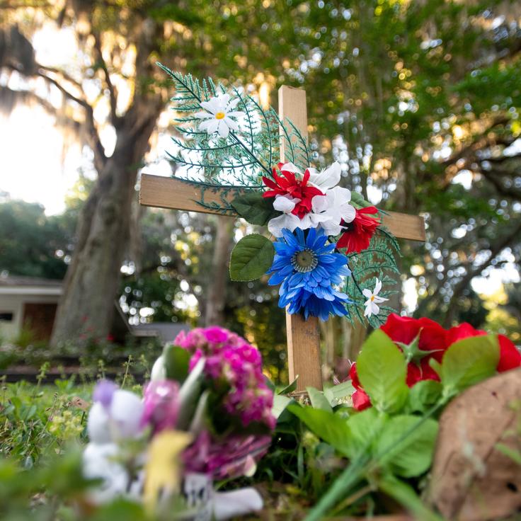 A cross and flowers are placed Thursday near the intersection where Ahmaud Arbery was fatally shot in the Satilla Shores neighborhood of Brunswick, Georgia.