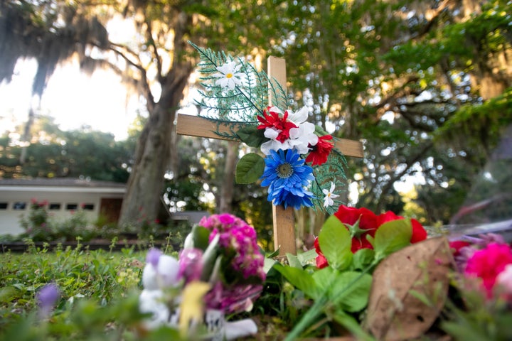 A cross and flowers are placed Thursday near the intersection where Ahmaud Arbery was fatally shot in the Satilla Shores neig