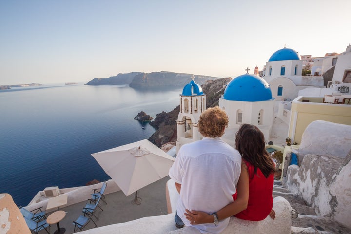 Couple of tourists looking at sunset, Santorini