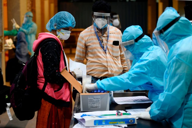 Health officials check the documents of a citizen evacuated from Dubai by an Air India flight at the...