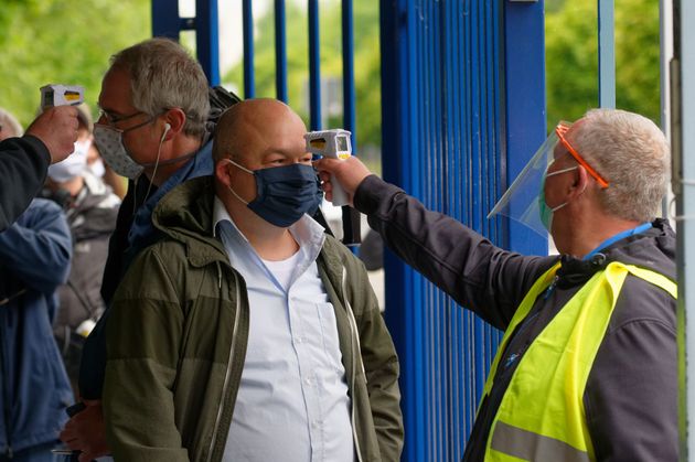 Employees measure visitors' temperatures at a Ford car factory in Germany on May 4.