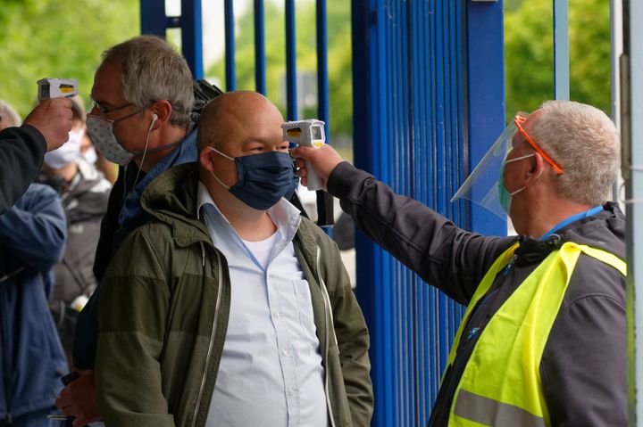 Employees measure visitors' temperatures at a Ford car factory in Germany on May 4.