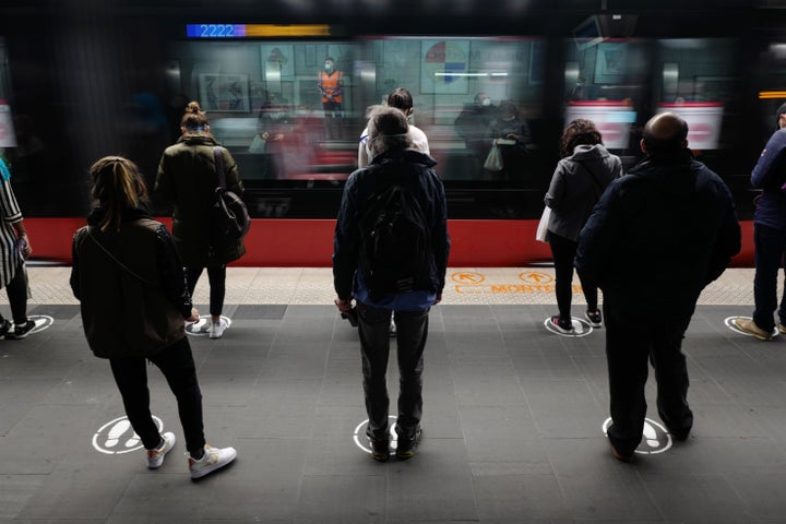 Commuters in Nice, France, wait on a tramway dock on May 11, abiding by the painted markers on the ground that help people maintain social distancing rules.