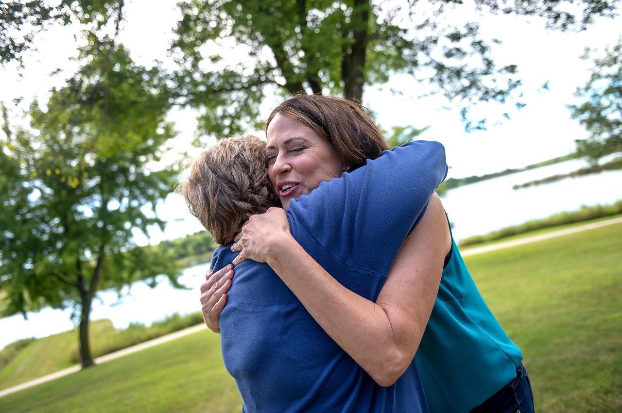 Theresa Greenfield hugs an attendee at a Democratic Party picnic this past August. Everywhere she goes, people come forward with their own stories about Social Security, the candidate said.