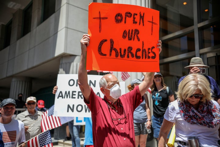 Demonstrators hold signs on May 1 during a rally in San Diego against California's stay-at-home directives.