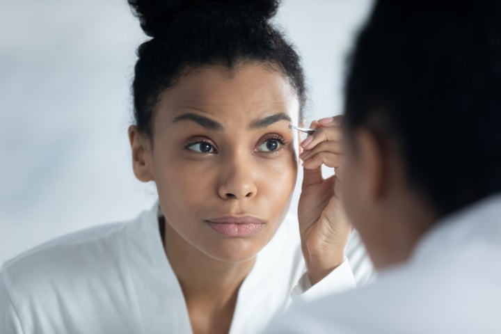 To tweeze properly, always use two hands: One to hold the skin tight and one to tweeze and remove one hair at a time. Try to use tweezers with a slanted tip and a tight closure to grip the tiniest of brow hairs.