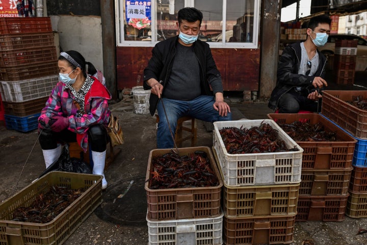 Vendors wear face masks as they offer prawns for sale at the Wuhan Baishazhou Market in Wuhan in China's central Hubei province.