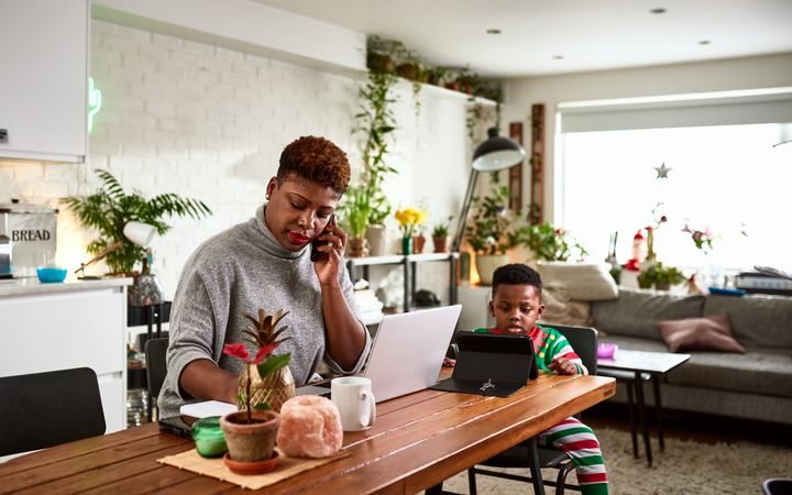 A multi-tasking mother looks after her young son while working from home in this undated stock photo. 