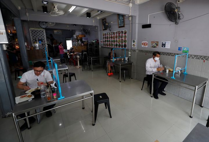 Πελάτες τρώνε το μεσημεριανό τους πίσω από πλαστικό προστατευτικό διαχωριστικό, σε εστιατόριο της Μπανγκόκ στην Ταϊλάνδη. 