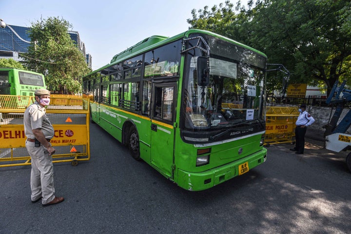 Delhi Police personnel stand guard as a bus reaches New Delhi Railway Station on May 7, 2020.