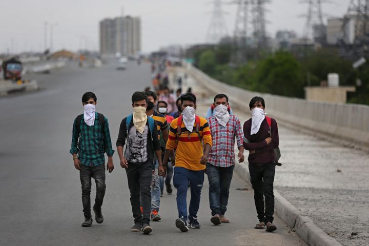 A group of daily wage labourers walk along an expressway on the outskirts of New Delhi on March 26, 2020.