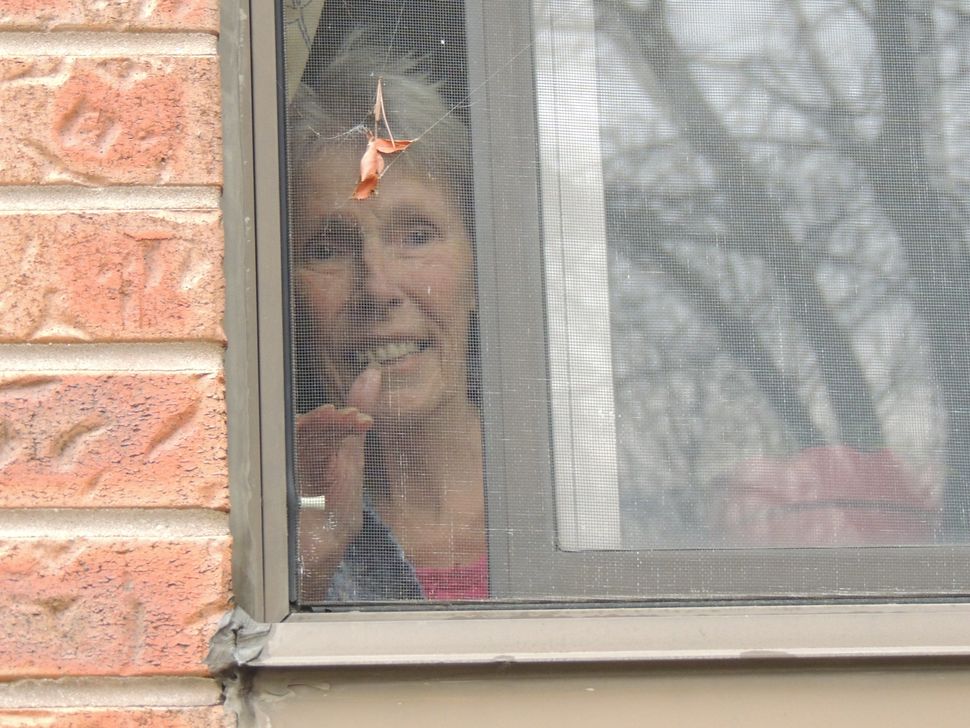 In an undated photo, Martha Grace waves to her daughter Brenda Shepherd through a window at Forest Heights Long Term Care in Kitchener, Ont.