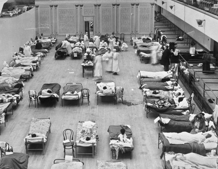 Volunteer nurses from the American Red Cross tend to influenza patients in the Oakland Municipal Auditorium, used as a temporary hospital for the 1918 Spanish flu pandemic. 