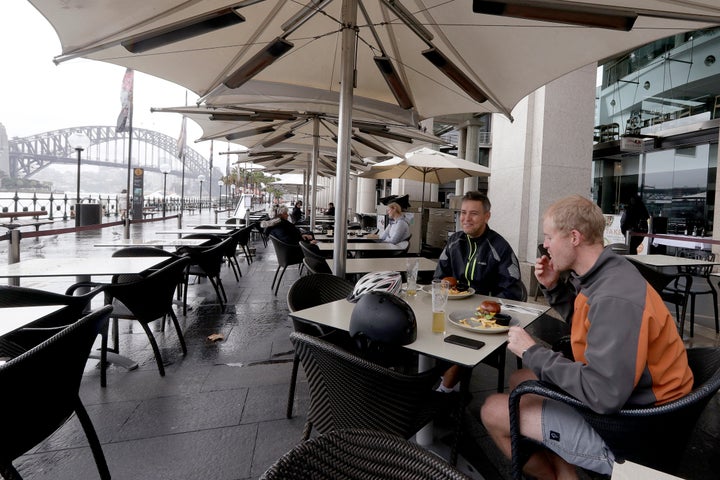 Rob Barton, right, and Charlie Downe have lunch at a restaurant along the shoreline as stage 1 of the lifting of COVID-19 restrictions begin in Sydney, Friday, May 15, 2020. Some pubs, clubs and restaurants are reopening with a limit of 10 patrons while following distancing guidelines.