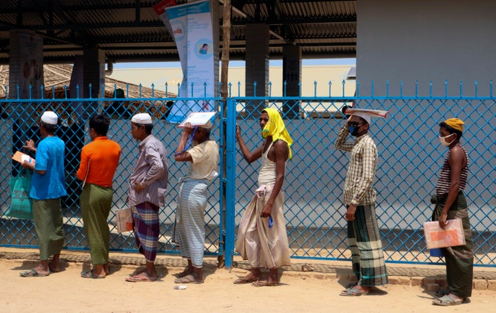 In this April 15, 2020, photograph, Rohingya refugees stand in line to collect food aid at the Kutupalong refugee camp in Cox's Bazar, Bangladesh. (AP Photo/Shafiqur Rahman)