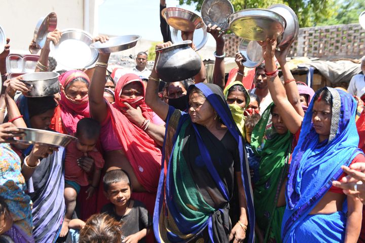Migrant labourers and families from Bihar and Uttar Pradesh states hold kitchen utensils as they protest against the government for the lack of food at a slum area, in Amritsar on April 22, 2020. 