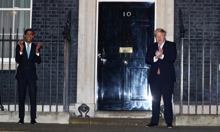 Prime Minister Boris Johnson and Chancellor Rishi Sunak clap outside 10 Downing Street in support of NHS workers, March 26, 2020.