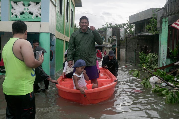 Residents ride a boat along a flooded village as Typhoon Vongfong passes by Sorsogon province, northeastern Philippines, on M