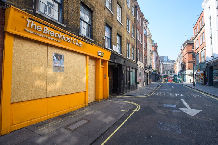 Empty streets and boarded up shops and restaurants in Soho, London.