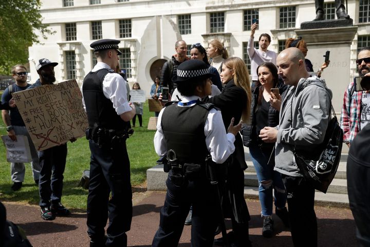 Police officers speak to people taking part in a coronavirus anti-lockdown, anti-vaccine, anti-5G and pro-freedom protest near Scotland Yard on Saturday May 2, 2020. (AP Photo/Matt Dunham)