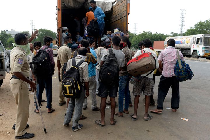 Migrant workers board on a truck to return to their hometowns after the government eased a nationwide lockdown as a preventive measure against the COVID-19 coronavirus, on the outskirts of Hyderabad on May 16, 2020.