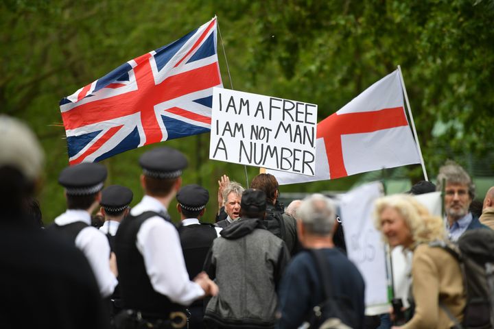 Protesters holding a Union Flag, a Flag of St George and a placard that reads "I am a free man, I am not a number" in Hyde Park.