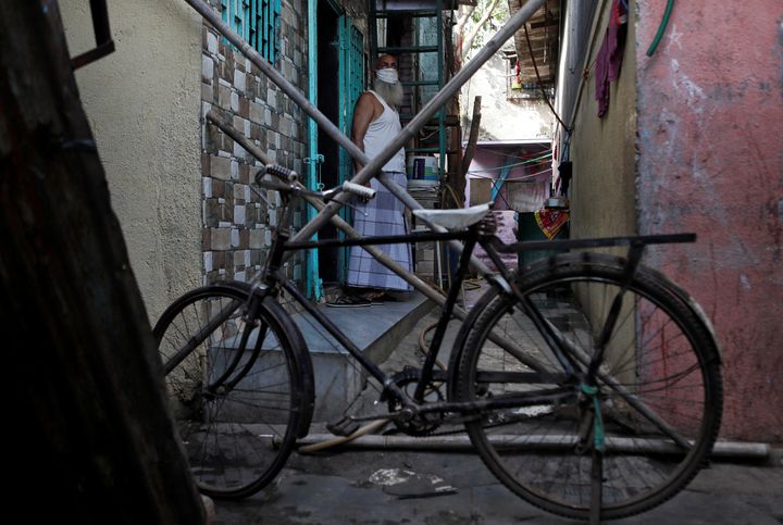 A man stands behind a makeshift barricade set up to stop people from entering a lane, during a nationwide lockdown in India to slow the spread of COVID-19, in Dharavi, one of Asia's largest slums, during the coronavirus disease outbreak, in Mumbai, India, April 9, 2020. REUTERS/Francis Mascarenhas SEARCH "CORONAVIRUS MUMBAI SLUM" FOR THIS STORY. SEARCH "WIDER IMAGE" FOR ALL STORIES. TPX IMAGES OF THE DAY