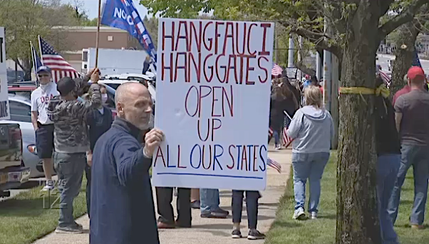 Protester holds threatening sign at Long Island protest against COVID-19 safety precautions.