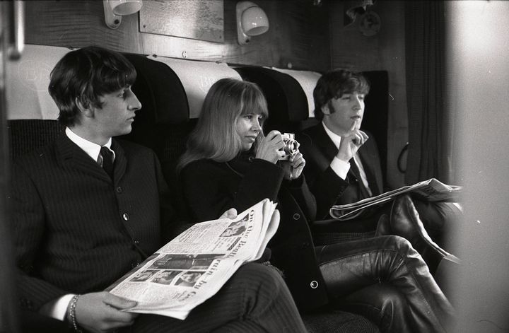 Ringo Starr, Astrid Kirchherr (holding camera) & John Lennon sitting on train during the filming of "A Hard Day's Night."
