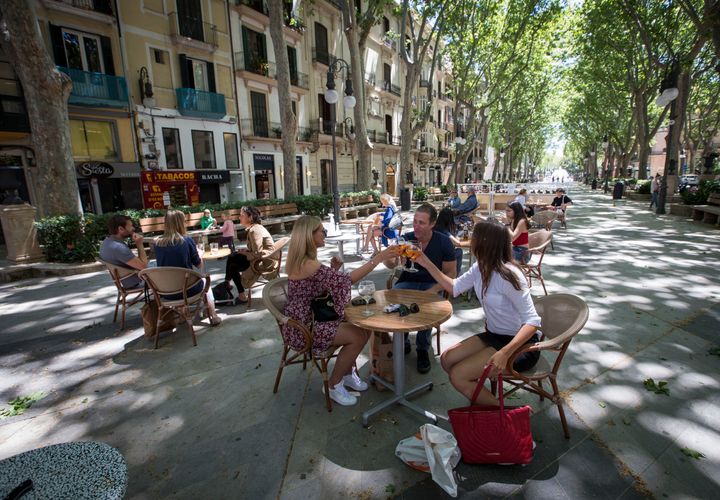 People share a toast at a terrace bar in Palma de Mallorca on May 11, as Spain moved towards easing its strict lockdown in certain regions.
