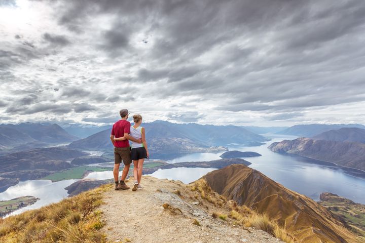 Tourist couple looking at view, Mt Roy, Wanaka, New Zealand