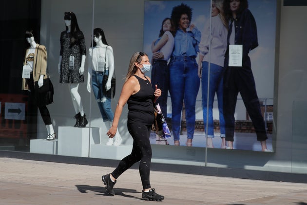 A woman passes a clothing shop in London as the country prepares to lift lockdown 