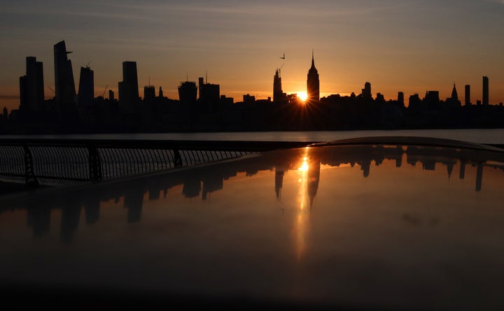 The sun rises behind the Empire State Building and Hudson Yards in New York City on May 14 as seen from Hoboken, New Jersey.